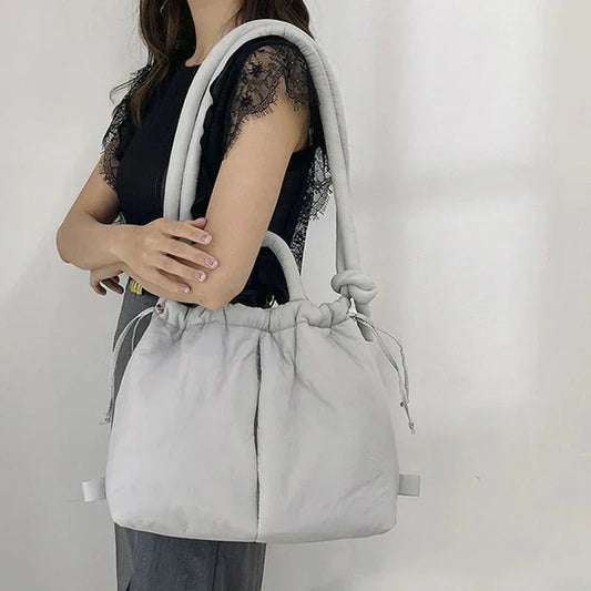 Women's quilted puffer tote bag with drawstring sides and knot-detail strap