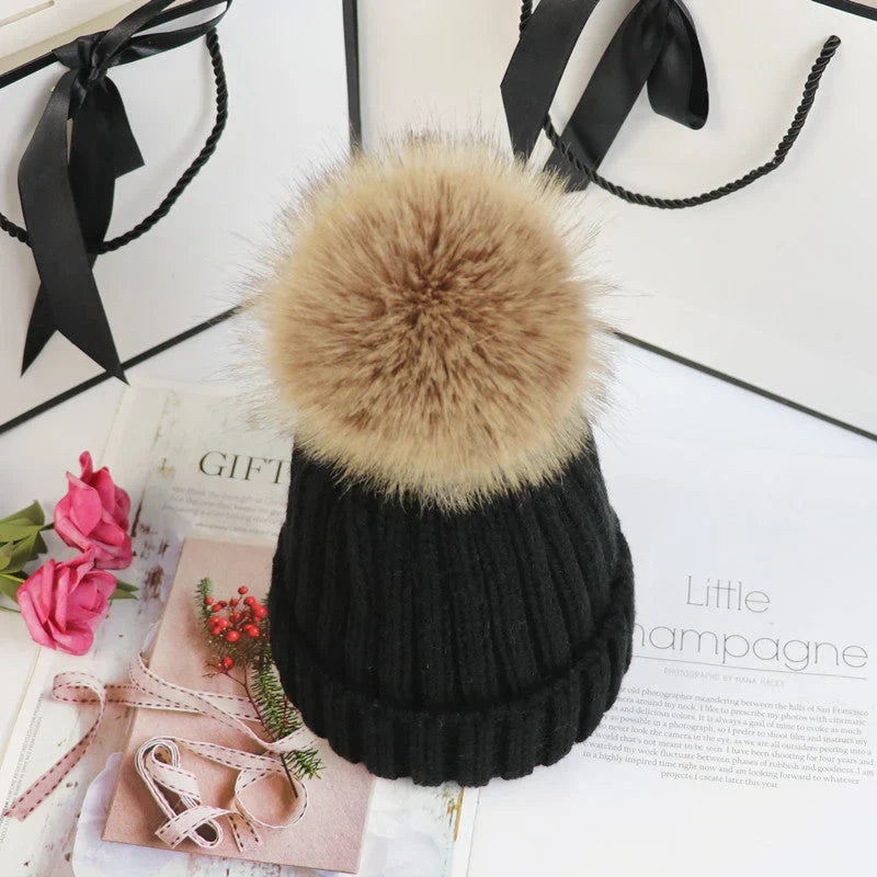 Women's cozy knit sweater-style beanie with faux fur pom