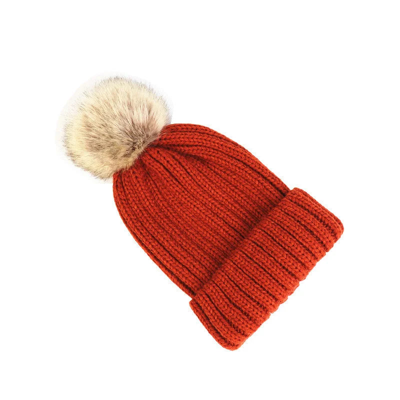 Women's cozy knit sweater-style beanie with faux fur pom