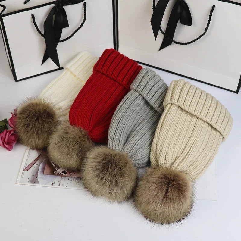 Women's cozy knit sweater-style beanie with faux fur pom