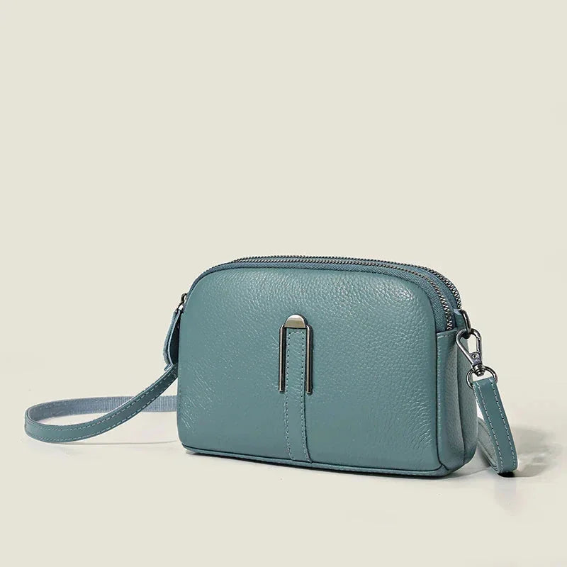Women's leather shoulder bag with double zip closure and metal accent