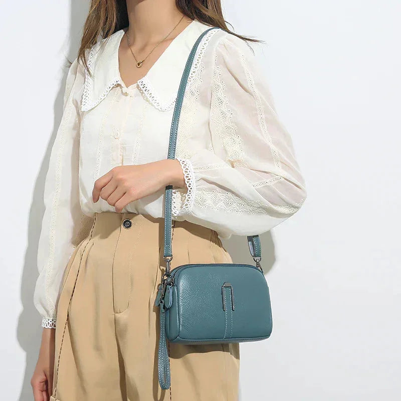 Women's leather shoulder bag with double zip closure and metal accent