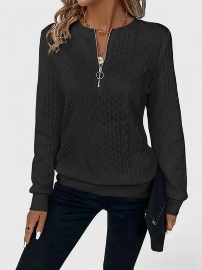 Women's cable-knit sweater with half-zip front and long sleeves