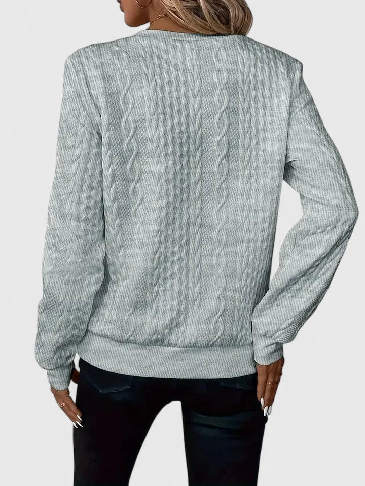 Women's cable-knit sweater with half-zip front and long sleeves