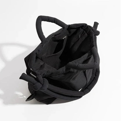 Women's quilted puffer tote bag with drawstring sides and knot-detail strap