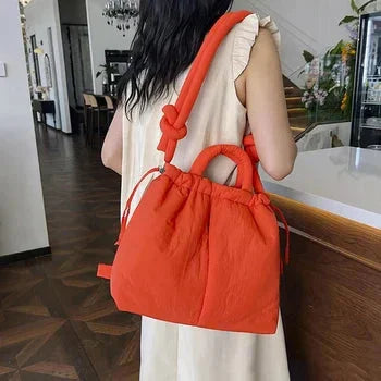 Women's quilted puffer tote bag with drawstring sides and knot-detail strap