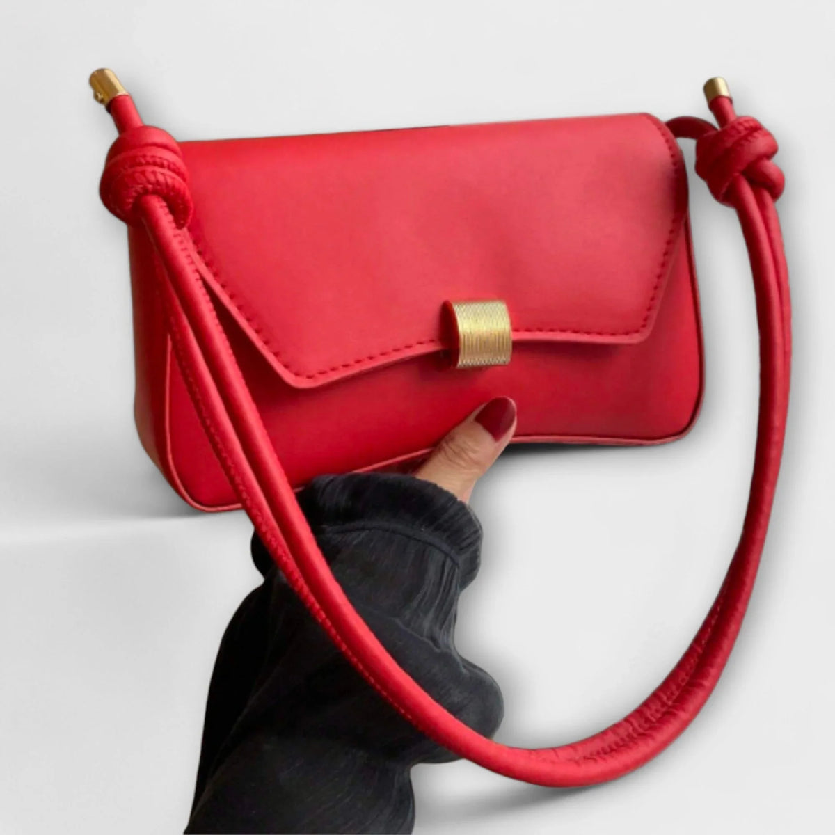 Women's solid color faux leather shoulder bag with flap closure and knotted strap