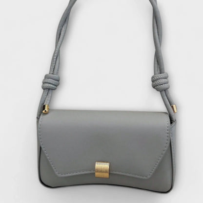 Women's solid color faux leather shoulder bag with flap closure and knotted strap