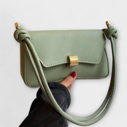 Women's solid color faux leather shoulder bag with flap closure and knotted strap