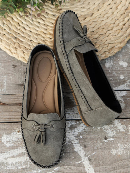 Women's suede slip-on loafers with front tassels and moccasin stitching