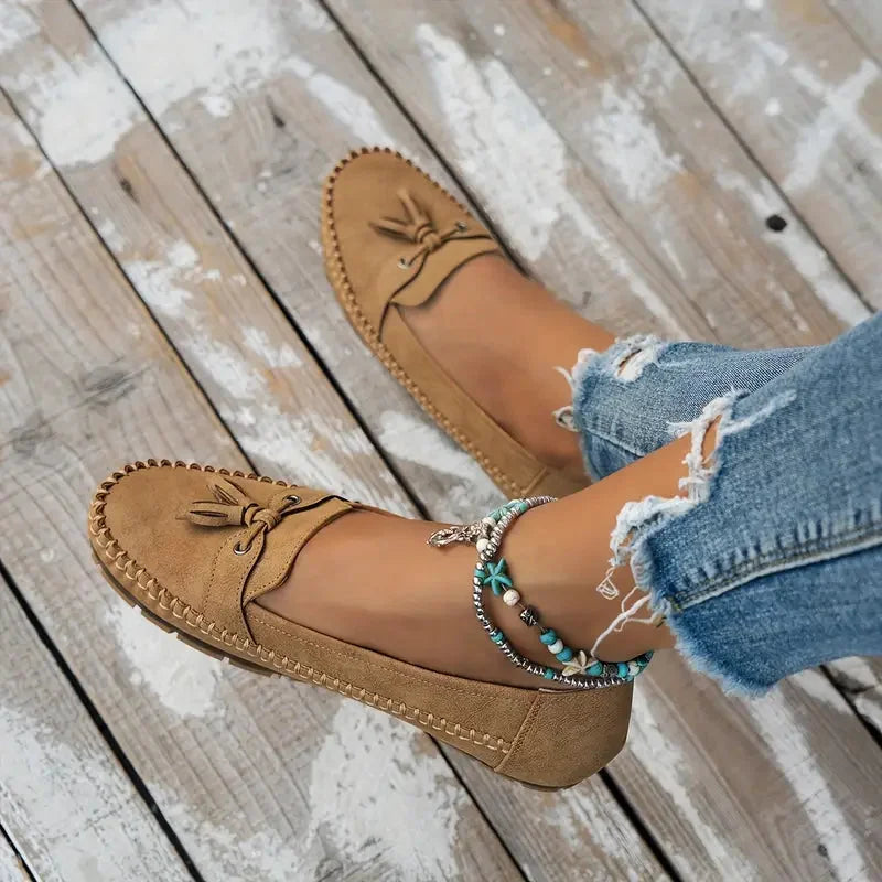 Women's suede slip-on loafers with front tassels and moccasin stitching