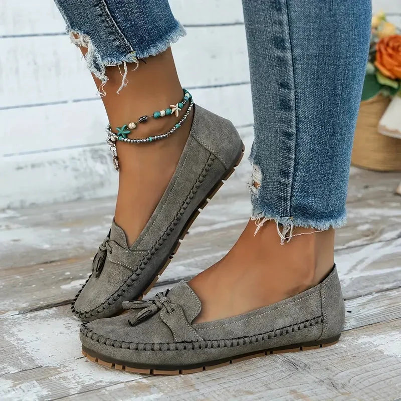 Women's suede slip-on loafers with front tassels and moccasin stitching
