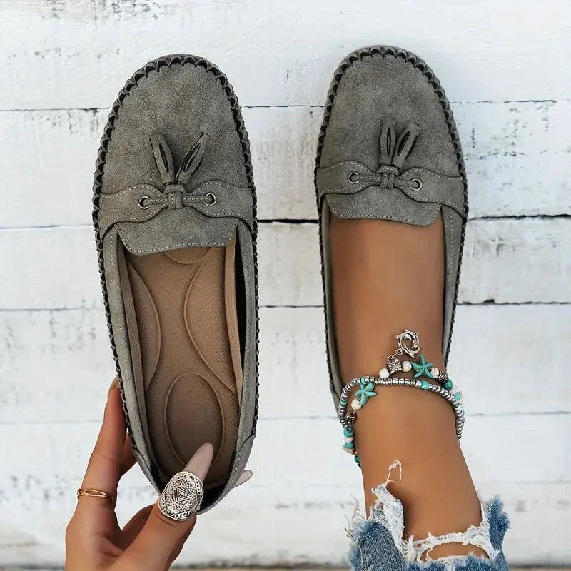 Women's suede slip-on loafers with front tassels and moccasin stitching