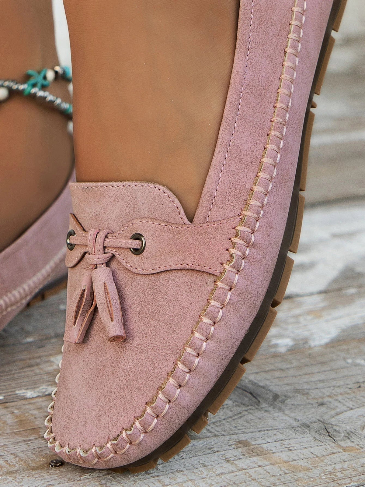 Women's suede slip-on loafers with front tassels and moccasin stitching