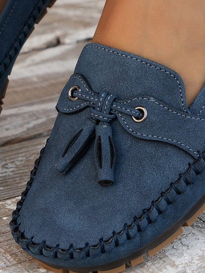 Women's suede slip-on loafers with front tassels and moccasin stitching