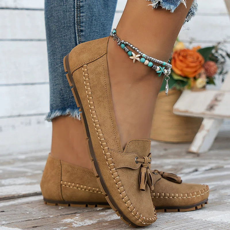 Women's suede slip-on loafers with front tassels and moccasin stitching