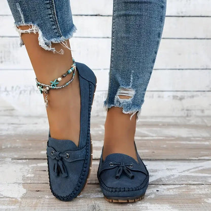 Women's suede slip-on loafers with front tassels and moccasin stitching