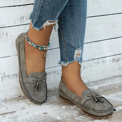 Women's suede slip-on loafers with front tassels and moccasin stitching